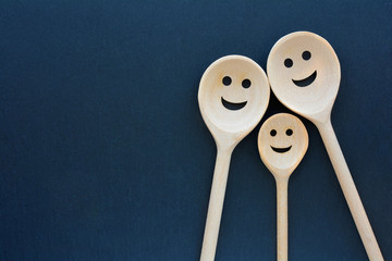 Wooden spoons look like happy family. Smiling faces.