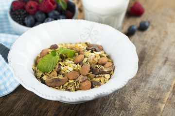 Homemade granola with fresh berries and mint, served with milk