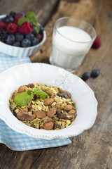 Homemade granola with fresh berries and mint, served with milk