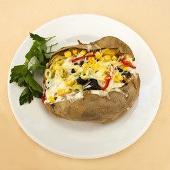 Baked kumpir potato stuffed with cheese, sausage, olives, peppers and corn