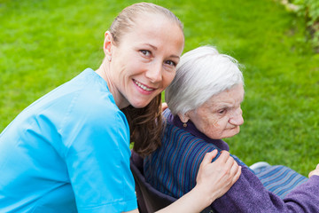 Cheerful carer with patient outdoor