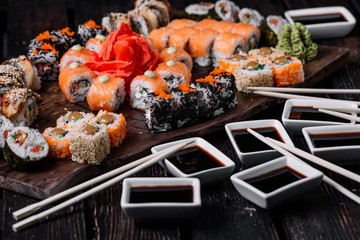 sushi large set and sticks on wood background