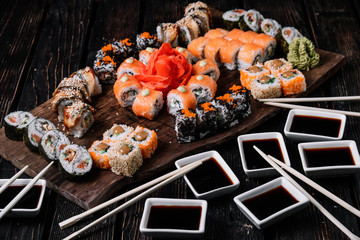 sushi large set and sticks on wood background