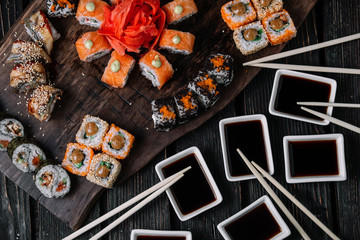 sushi large set and sticks on wood background