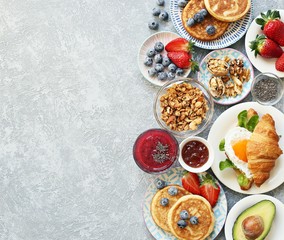 Breakfast food table. Festive brunch set, meal variety with granola, fried egg, pancakes,...