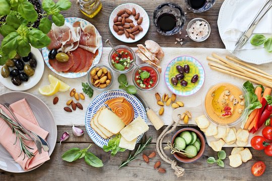 Mediterranean Appetizers Table Concept. Diner Table With Tapas Selection: Cured Meat And Salami, Gazpacho Soup, Jamon, Olives, Cheese, Hummus And Vegetables.   Overhead View.