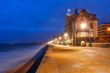 Obraz premium Night view of beautiful walled port city of Privateers Saint-Malo is known as city corsaire, high stone embankment at high tide, Brittany, France