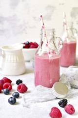Berry smoothies in a vintage bottles with paper straws.