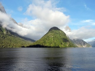 Clouds and green mountains in Milford Sound, New Zealand