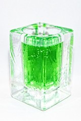 Liquid of poisonous bright color in a glass transparent vessel on a light background
