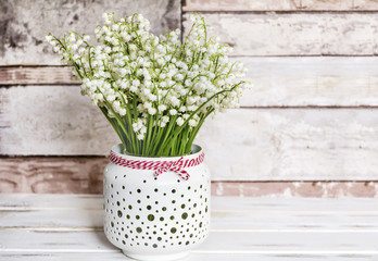 Lily of the Valley Bouquet in  Vase with Pink Ribbon .Spring Flowers Background