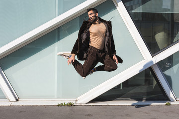 Young Indian man jumping in an urban context
