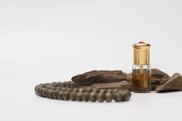 Fotobehang Bottle of oil agarwood perfume with Incense Chips isolated on white background © Wasim Alnahlawi