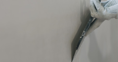 worker applying putty on the wall
