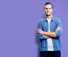 Portrait of young man standing in crossed arms pose