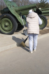 A woman with a broom cleans the area