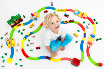 Child with toy train. Kids wooden railway.