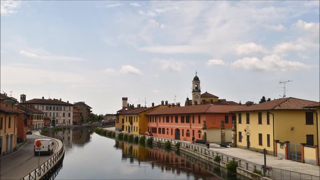 Cityscape of Gaggiano, just outside of Milan, Italy. Colourful houses reflected in the Naviglio Grande canal waterway.