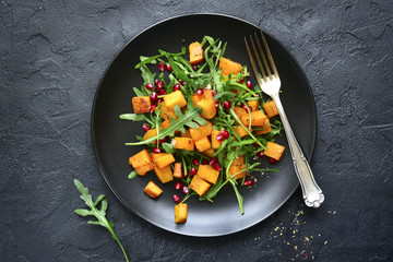 Pumpkin salad with pomegranate seed and arugula.Top view with copy space.