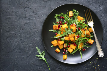 Pumpkin salad with pomegranate seed and arugula.Top view with copy space.