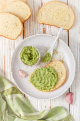 Traditional Latinamerican mexican guacamole sauce  and avocado sandwiches on light wooden background