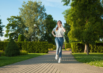 Happy young woman jogging in a park