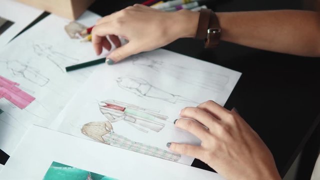 designer of clothes makes an outline of clothes with a felt-tip pen. female hands closeup