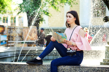 Portrait of a young girl in the city . Girl in jeans and blouse on the streets