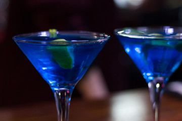 Blue drink fancy glasses with green olive and lemon slice