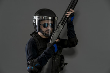 Guard policeman with full equipment for anti-riot, Law enforcer in protective uniform ready for crowd control isolated on black