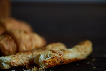 Puff pastries on dark wooden table, close-up, selective focus, shallow depth of field.