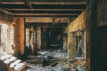 Fototapeta na wymiar Ruins of industrial building interior after disaster or war or earthquake. Dark creepy tunnel or corridor, horror atmosphere