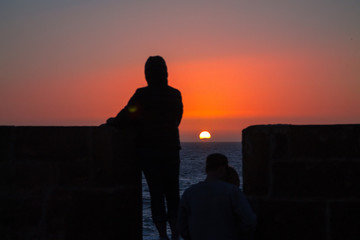 City wall in Essaouira at sunset human silhouettes. Seaport. Africa