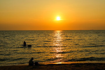 Naklejka na ściany i meble silhouette child play on beach and sunset