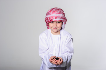 Young arabic boy holding young plant in the hands.