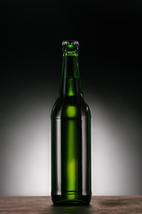 close up view of bottle of beer on dark grey backdrop