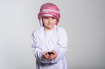 Young arabic boy holding young plant in the hands.
