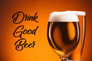 close up view of arrangement of glasses of beer and drink good beer inscription on orange backdrop