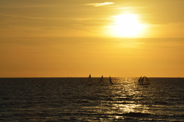Fototapeta na wymiar Boats Sailing On Sea Against Sky During Sunset