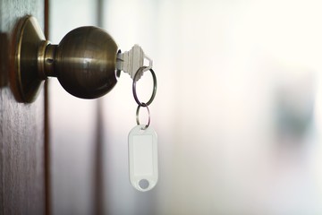 House key with home keyring in keyhole, property concept, empty tag