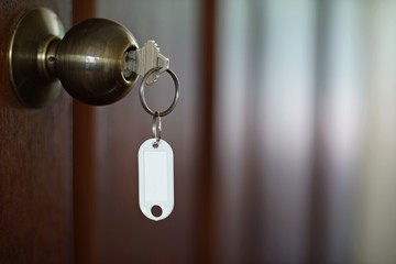 House key with home keyring in keyhole, property concept, empty tag