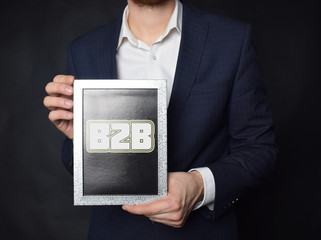 In the hands of a businessman a frame with the inscription:B2B