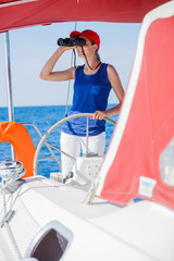 Girl captain on board of sailing yacht on summer cruise. Travel adventure, yachting with child on family vacation.