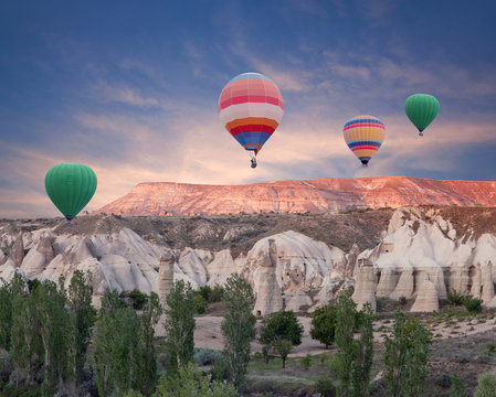 Colorful hot air balloons flying over Red valley in Cappadocia, Anatolia, Turkey