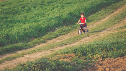 Boy rides a balance bike in the countryside