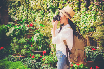 Beautiful woman taking photo tourist in flower garden