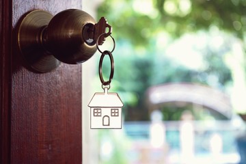 House key with home keyring in keyhole, property concept