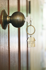 House key with home keyring in keyhole, property concept - 203796314