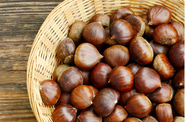 Castanea sativa or sweet chestnut in the basket on wooden background.
