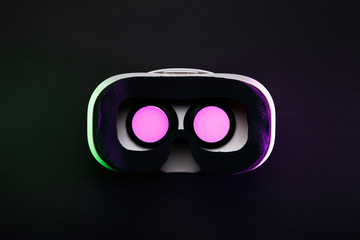 Picture of virtual reality glasses with burning pink light on black background